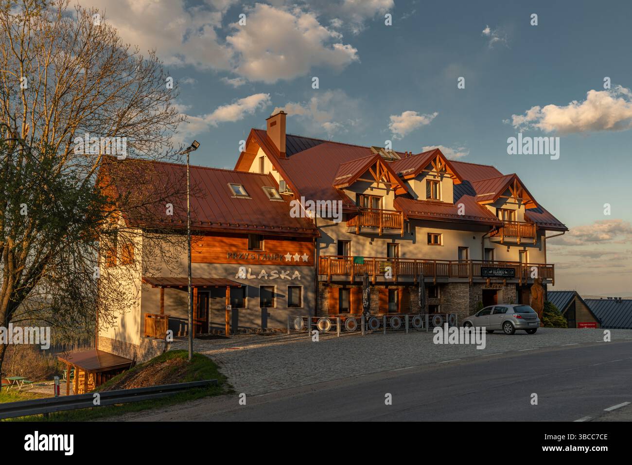 Hôtel en bois sous colline et montagnes Orlicke hory avec coucher de soleil à Zieleniec Pologne 04 28 2025 Banque D'Images