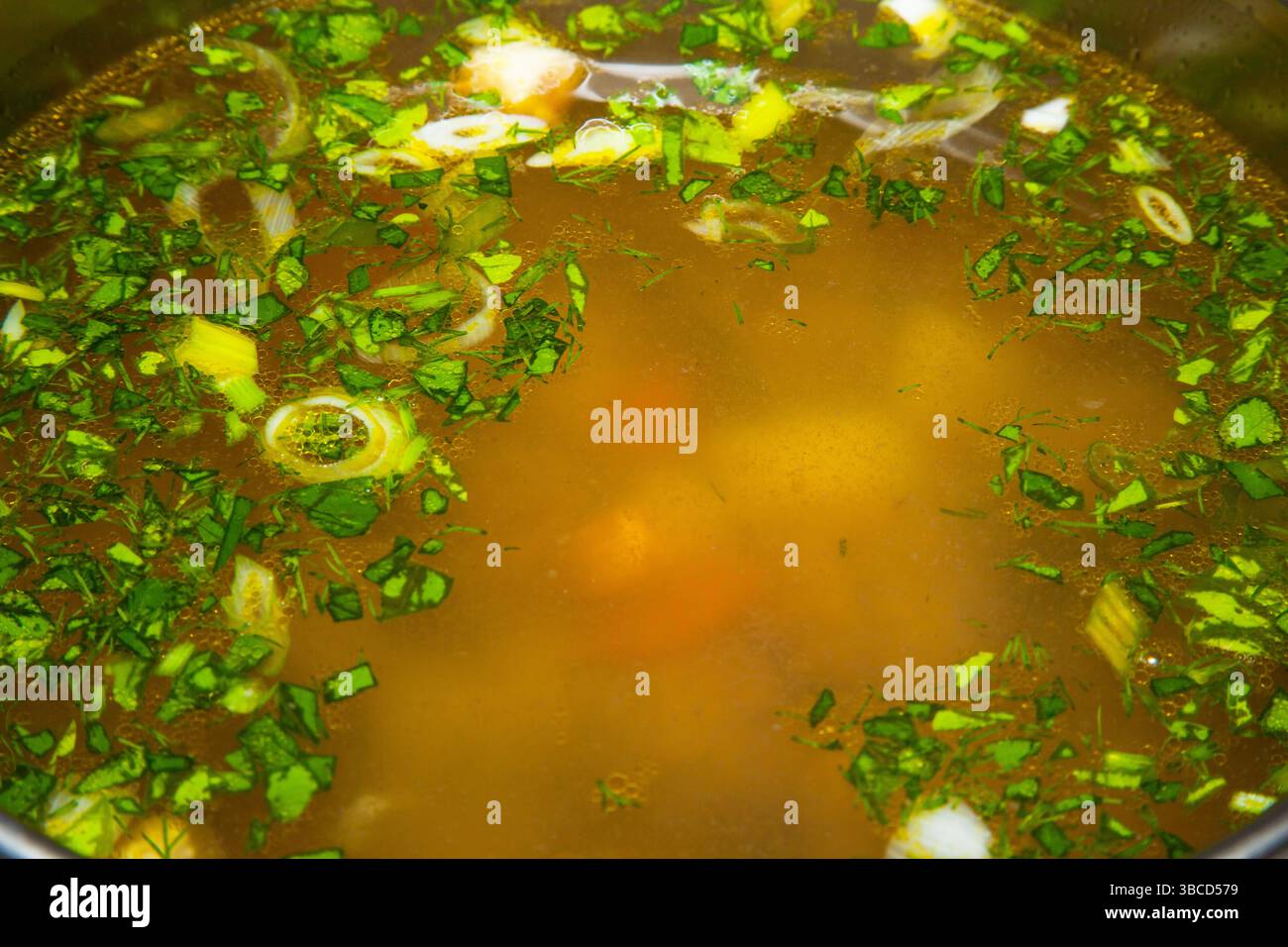 Soupe avec boulettes de viande, légumes, herbes et oeufs dans une casserole gros plan. Banque D'Images