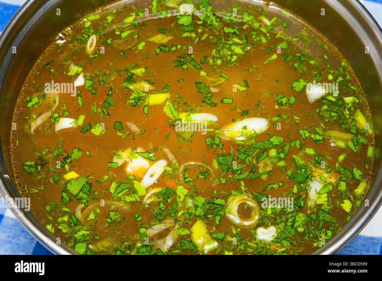 Soupe avec boulettes de viande, légumes, herbes et oeufs dans une casserole gros plan. Banque D'Images