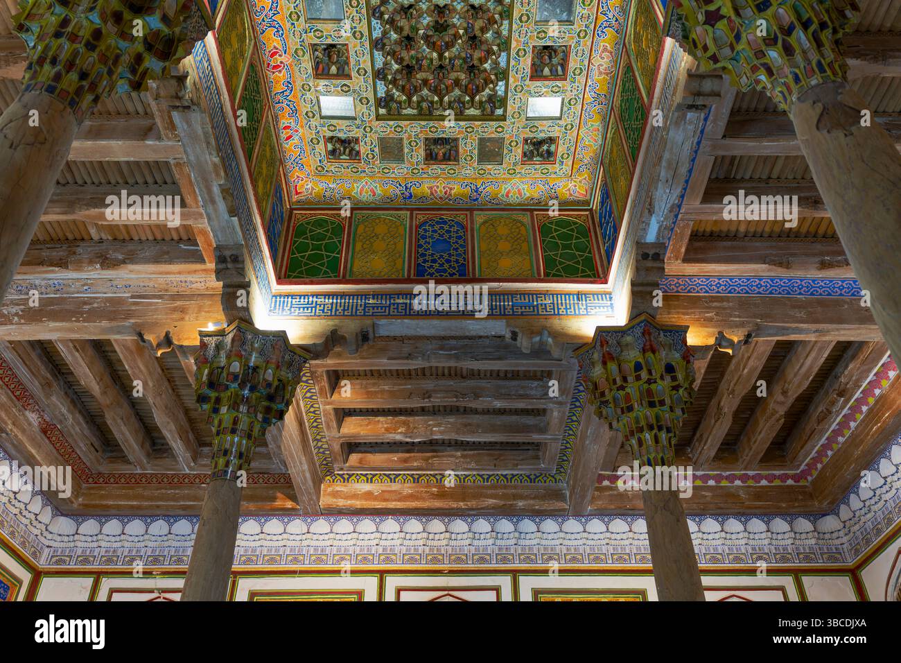 À l'intérieur de la forteresse Ark à Boukhara, Ouzbékistan, le plafond de la mosquée Jome affiche des motifs géométriques vibrants et des poutres en bois somptueuses. Banque D'Images