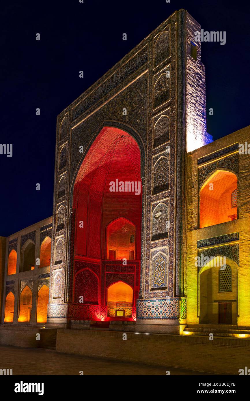La façade de la mosquée Kalon brille sous les lumières de nuit à Boukhara, Ouzbékistan, révélant des tilework complexes et une grande architecture islamique. Banque D'Images