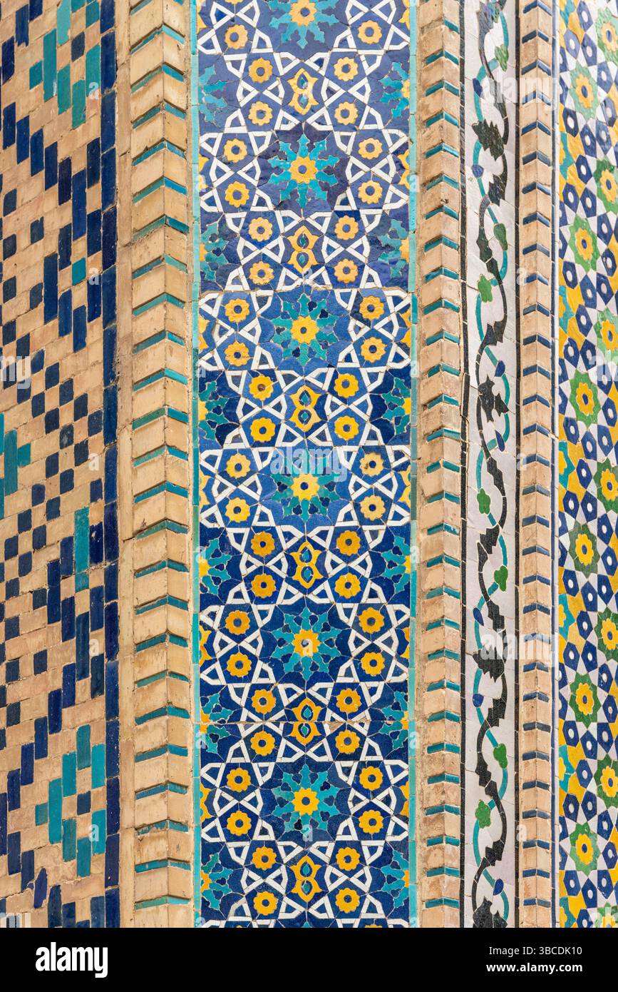 Une colonne de la Madrasah Nadir Divan Begi à Boukhara, en Ouzbékistan, est recouverte d'une mosaïque géométrique bleue, jaune et blanche en motifs islamiques. Banque D'Images