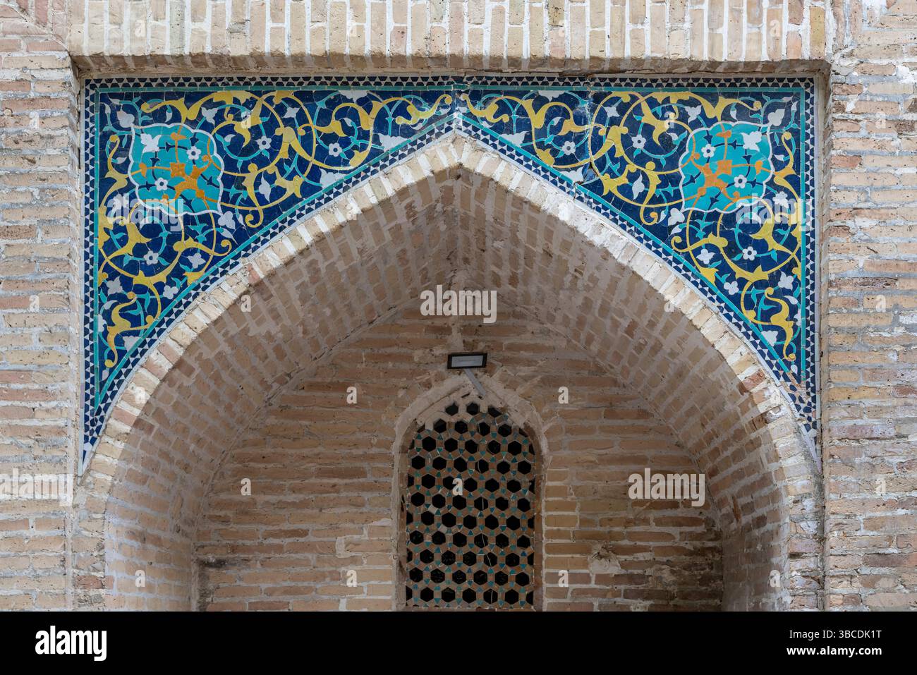 Le carrelage bleu et jaune avec des motifs floraux décore le portail arqué de la Madrasah Nadir Divan Begi à Boukhara, Ouzbékistan. Banque D'Images