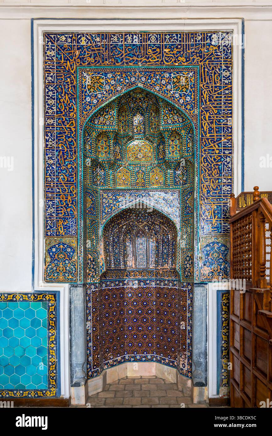 Le mihrab de la mosquée Kalyan à Boukhara, Ouzbékistan, est richement orné de carreaux bleus et de motifs floraux, marquant la direction de la Mecque. Banque D'Images
