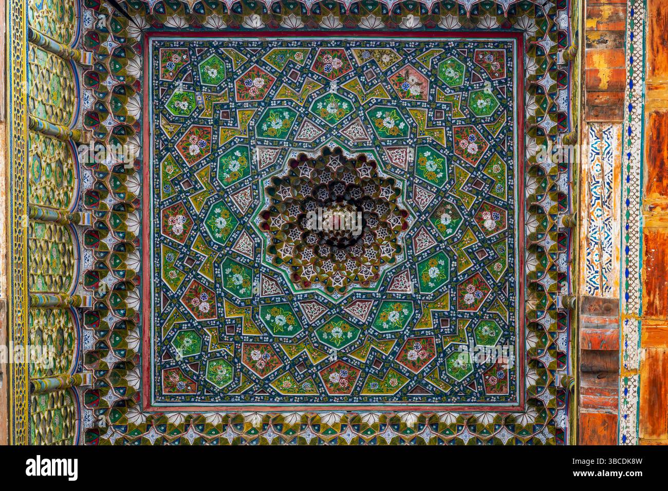 Un plafond avec des motifs floraux et géométriques peints remplit la mosquée Boloi Havz à Boukhara, Ouzbékistan, de couleurs vives et d'art islamique. Banque D'Images