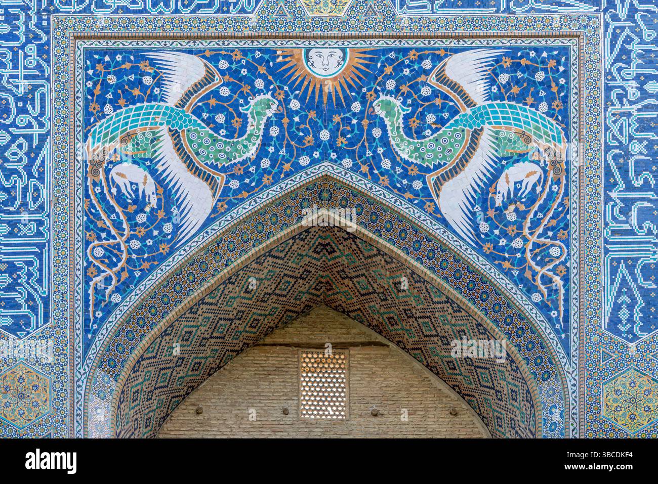 Des oiseaux mythiques en mosaïque bleue volent au-dessus du portail de la Madrasah Nadir Divan Begi à Boukhara, en Ouzbékistan, symbole de bonheur et de légende. Banque D'Images