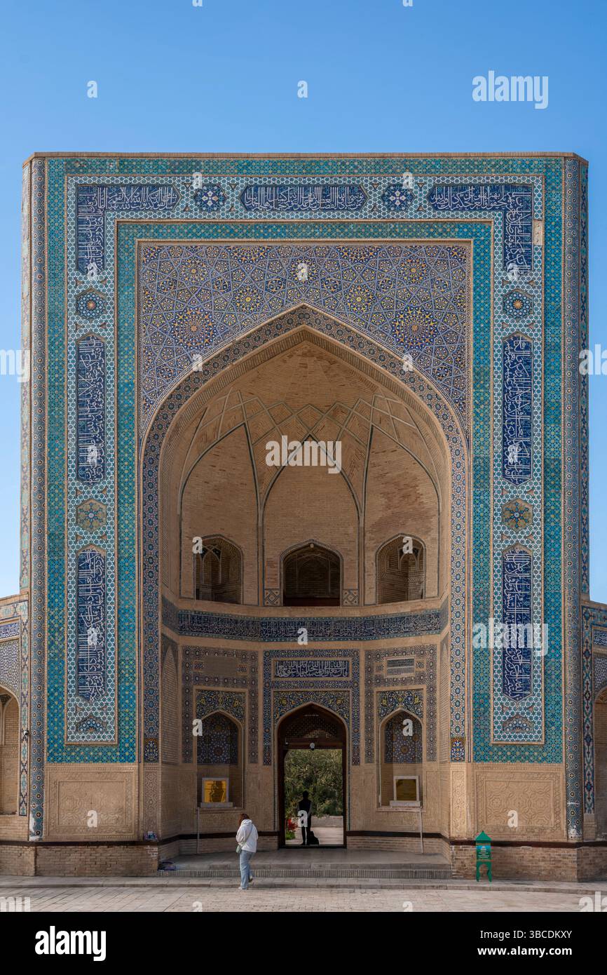 Des mosaïques bleues et des calligraphies encadrent l’entrée de la mosquée Kalyan à Boukhara, en Ouzbékistan, reflétant l’héritage islamique de la ville. Banque D'Images
