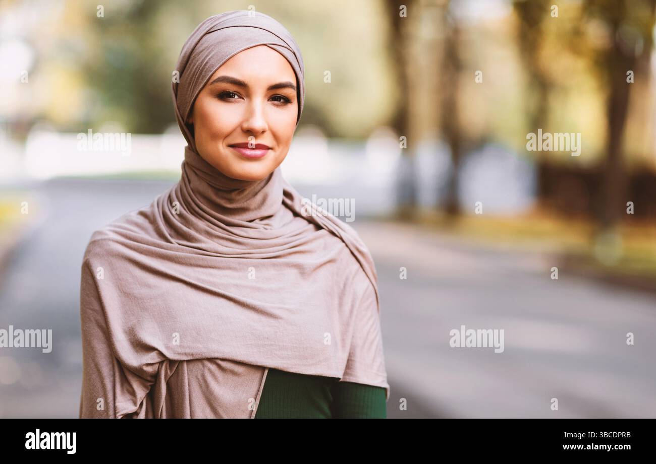 Portrait d'une femme musulmane heureuse portant le hijab traditionnel debout à l'extérieur Banque D'Images