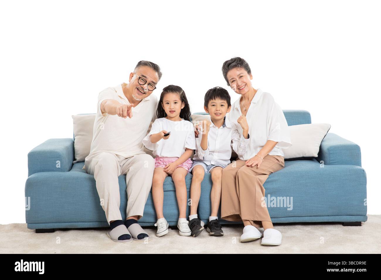 Quatre générations (grands-parents et petits-enfants) regardant la télévision sur le canapé Banque D'Images
