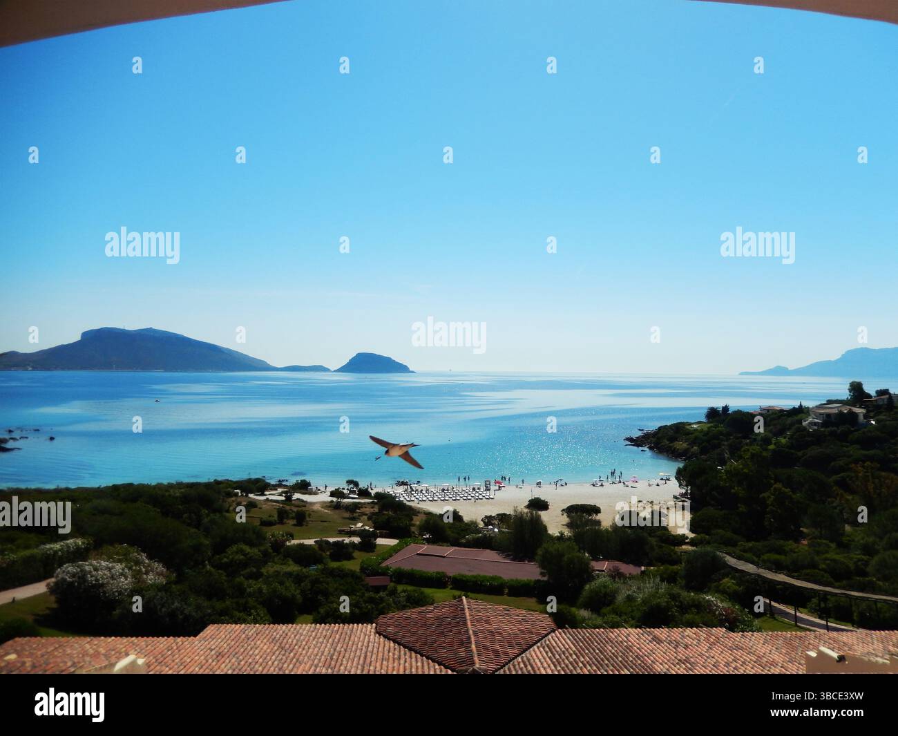 Tapis de paille suspendu au vent sur une cabane sur une plage de sable blanc en face d'une mer bleu vif, Golfo Aranci, Sardaigne, Italie Banque D'Images
