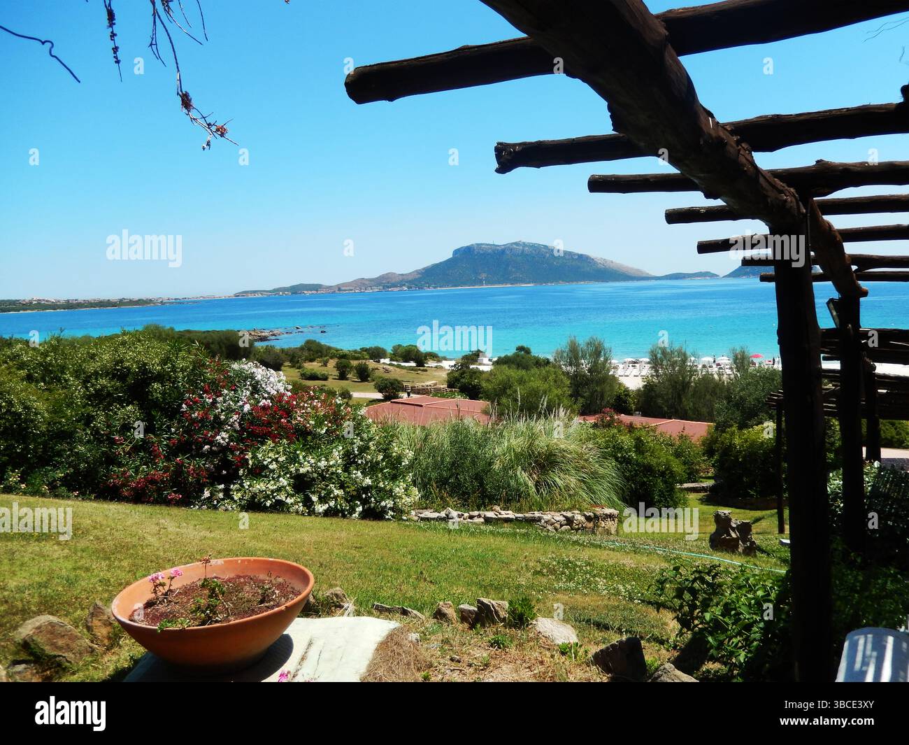 Tapis de paille suspendu au vent sur une cabane sur une plage de sable blanc en face d'une mer bleu vif, Golfo Aranci, Sardaigne, Italie Banque D'Images