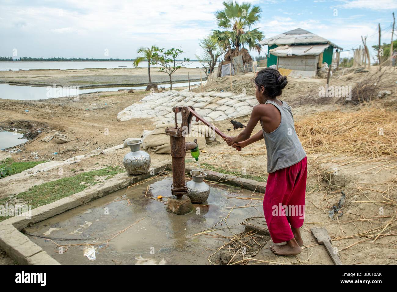 Les Bangladais transportent de l'eau potable après l'avoir recueillie d'une source d'eau douce dans la zone côtière de Banshkhali, Chittagong Banque D'Images