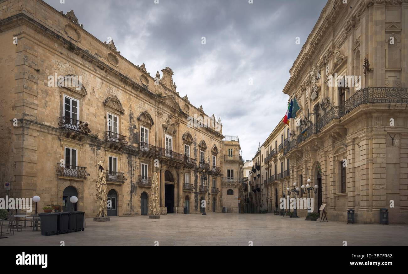 En se promenant dans Ortigia, les visiteurs admirent les bâtiments baroques complexes et un ciel dramatique, rehaussant l'ambiance, Sicile, Italie Banque D'Images