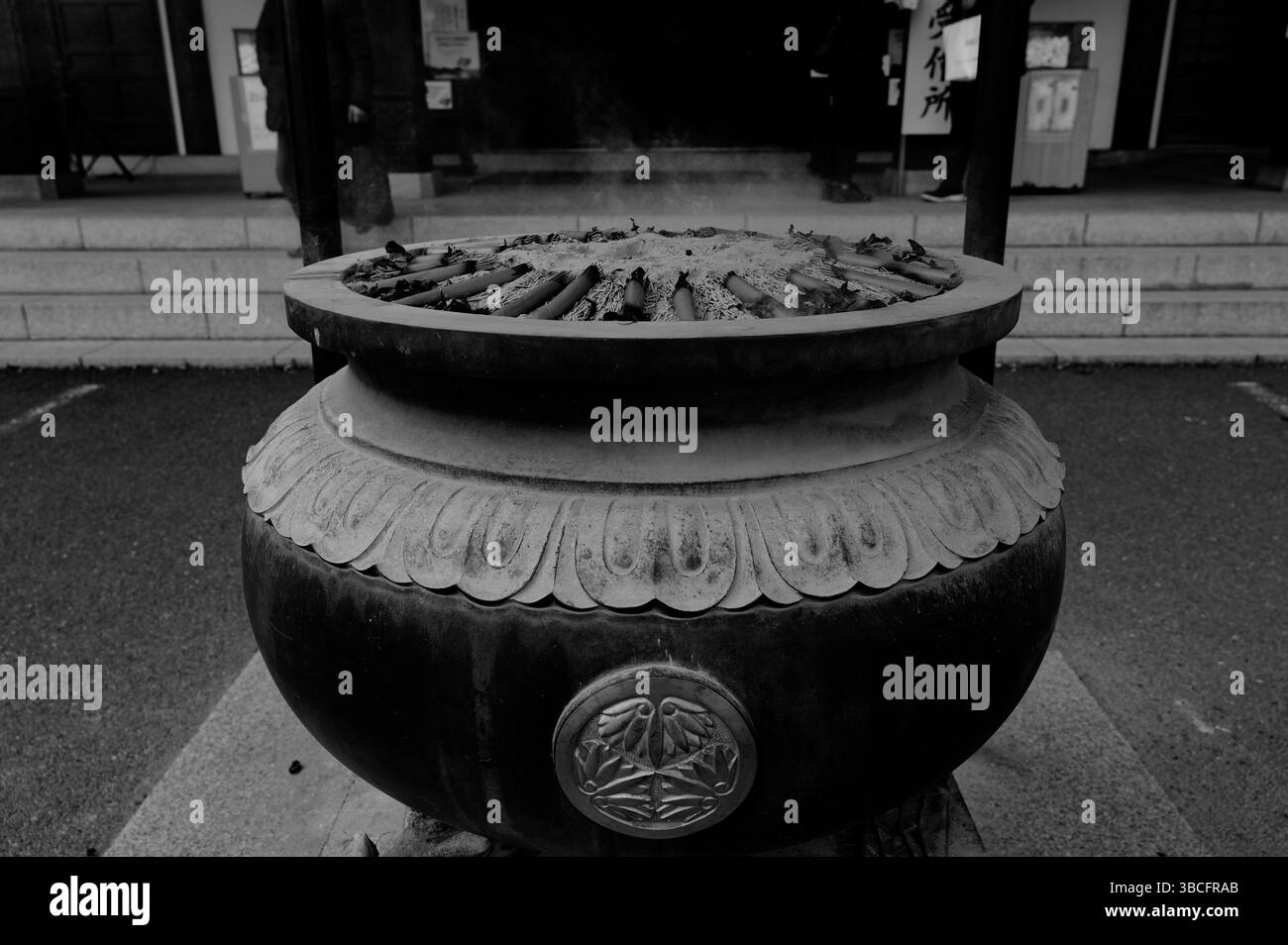 La fumée silencieuse dérive d'un brûleur d'encens de temple en monochrome Banque D'Images