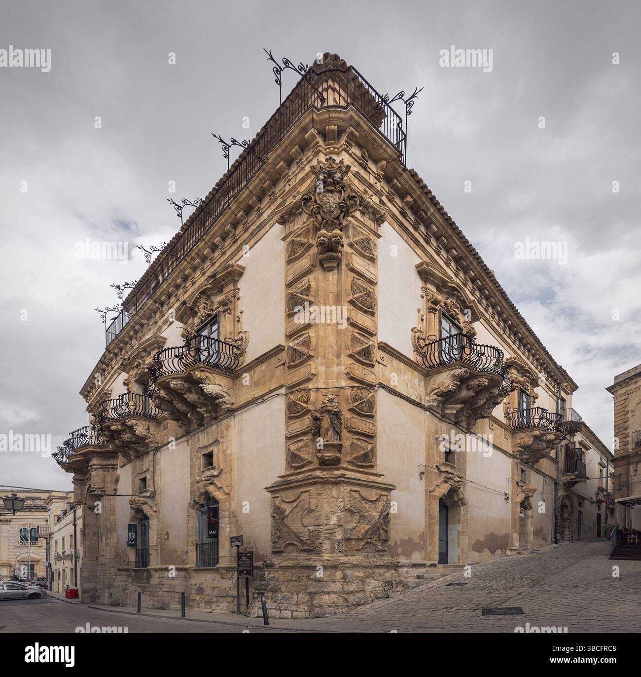 Les façades majestueuses et les balcons complexes mettent en valeur l'art des bâtiments baroques de Scicli par un jour nuageux, en Italie Banque D'Images
