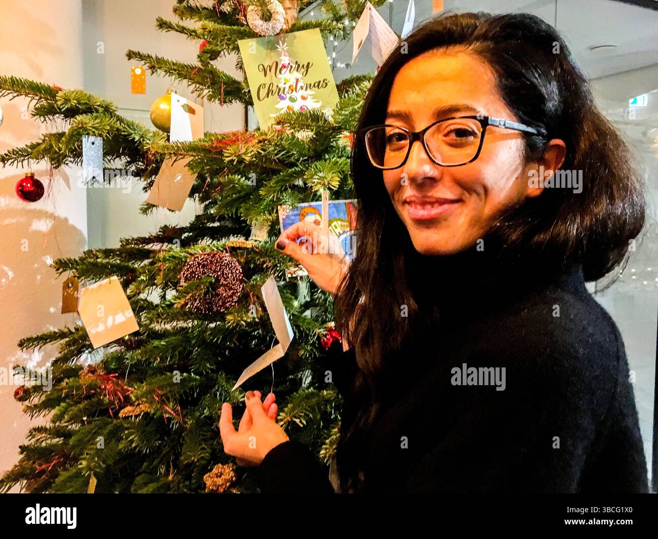 Jeune femme italienne à l'arbre de Noël du Centre International. Tilburg, pays-Bas. Banque D'Images