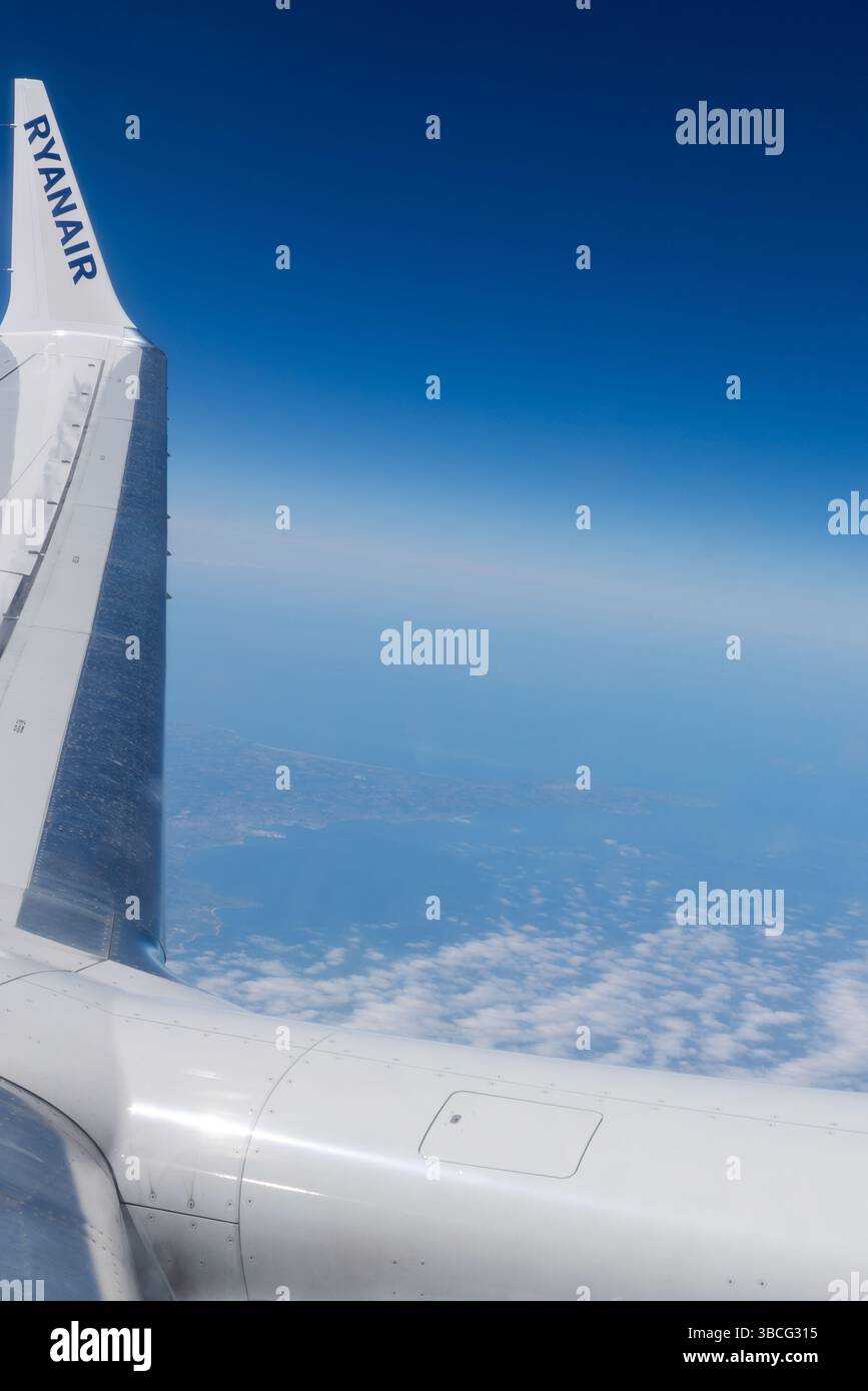 Aile d'un Boeing 737 MAX 8200 de Ryanair volant à haute altitude de croisière au-dessus de la France, avec un ciel bleu profond. Titres Ryanair sur ailette de bout d'aile Banque D'Images