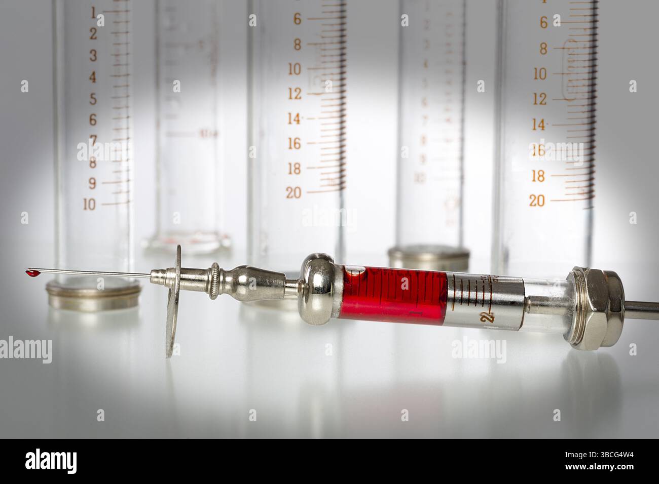 Seringue avec du sang et des seringues en verre vides en arrière-plan Banque D'Images