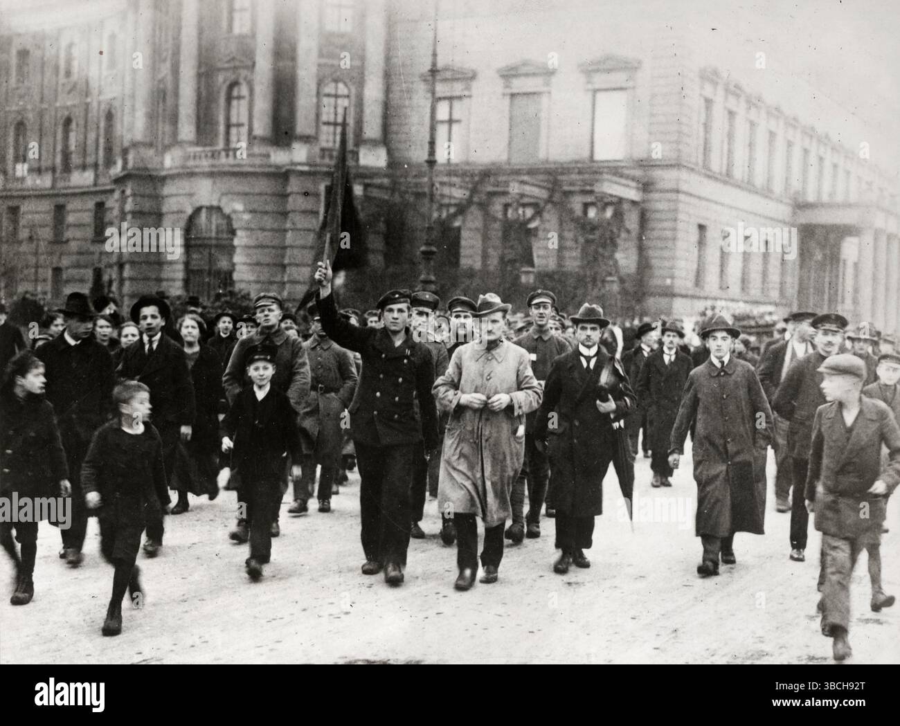 Un marin allemand portant un drapeau lu menant un groupe de manifestants pendant le soulèvement spartaciste. Le soulèvement spartaciste était un soulèvement armé à Berlin du 5 au 12 janvier 1919. Il s’agissait avant tout d’une lutte de pouvoir entre les partisans du gouvernement provisoire qui favorisait une social-démocratie, et ceux du Parti communiste allemand (KPD) dirigé par Karl Liebknecht et Rosa Luxemburg, qui voulaient mettre en place une république soviétique similaire aux bolcheviks de Russie. Banque D'Images