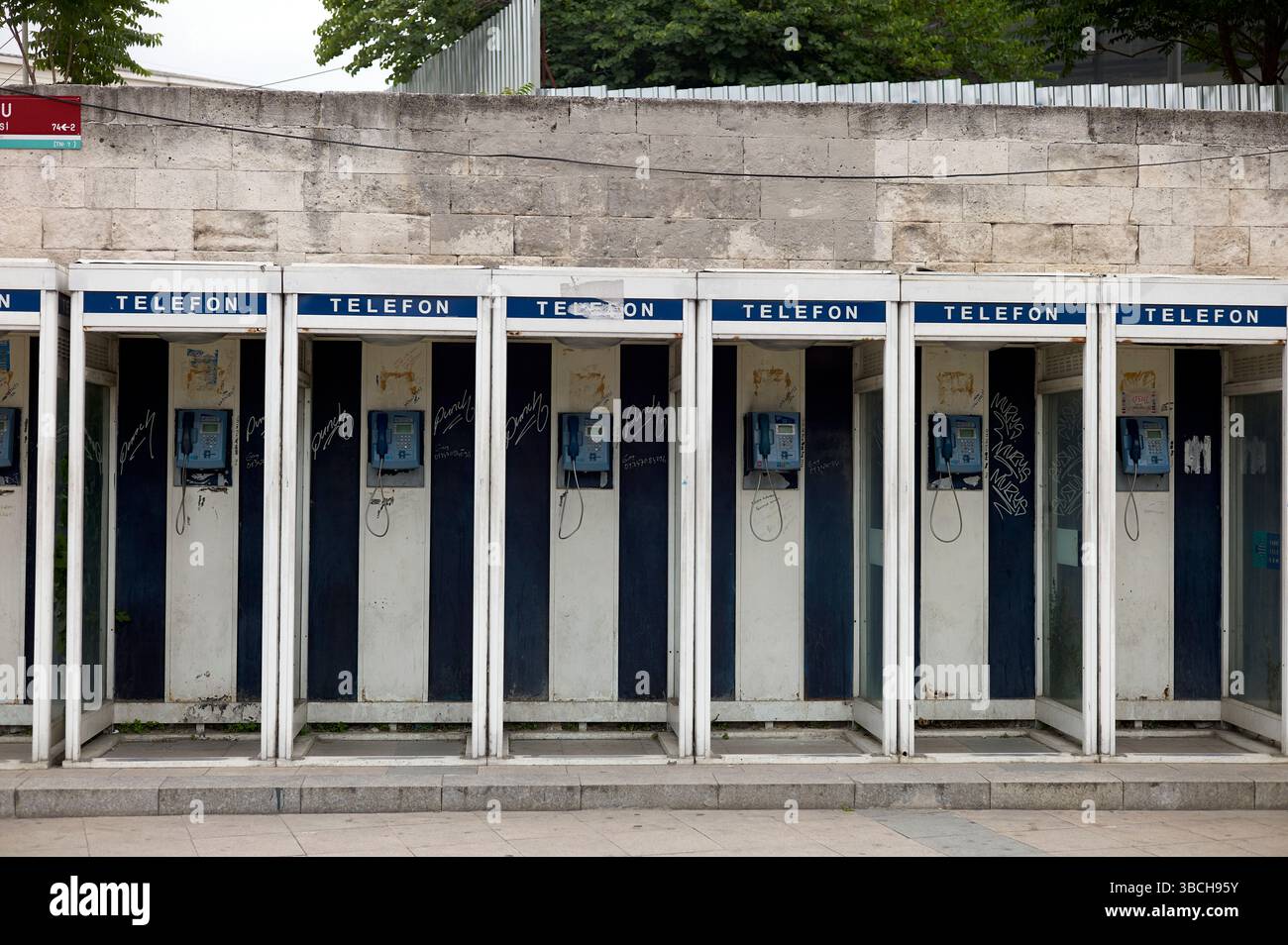 Rangée de vieilles cabines téléphoniques vides avec des murs en béton usés et des graffitis dans un cadre urbain. Istanbul, Turquie Banque D'Images