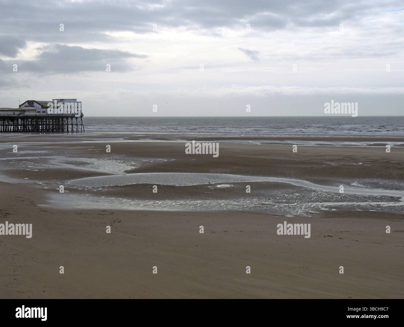 Vue sur la jetée sud de blackpool avec la plage à marée basse devant la mer et un ciel nuageux Banque D'Images