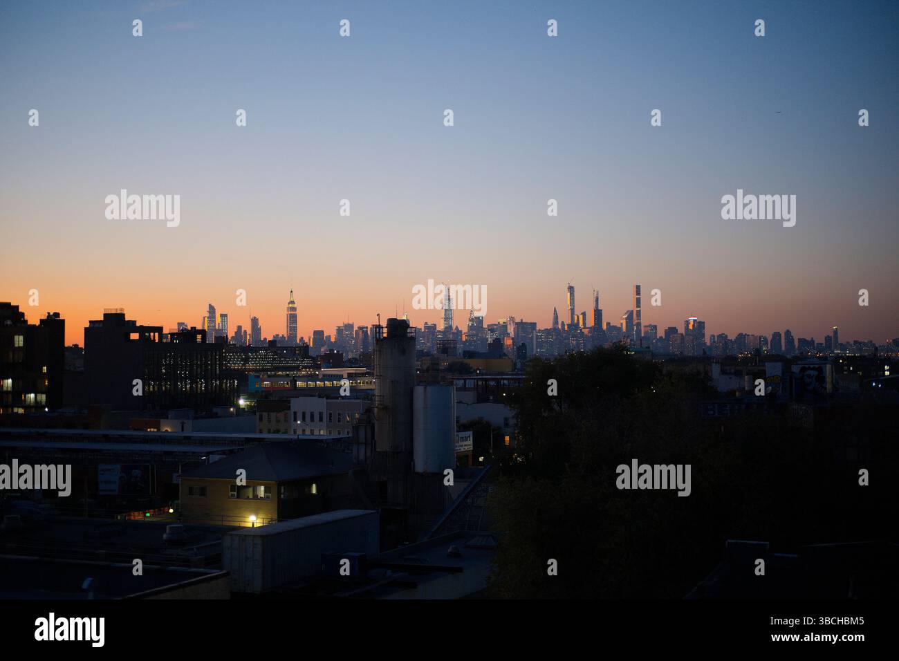 Horizon de New York au crépuscule avec de hauts bâtiments silhouettés sur un ciel coloré de coucher de soleil. New York, États-Unis Banque D'Images