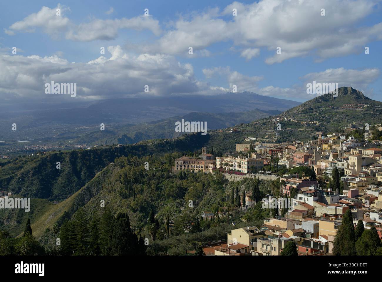 Une vue panoramique d'une ville sur une colline avec des montagnes et des nuages en arrière-plan. Sicile, Italie Banque D'Images