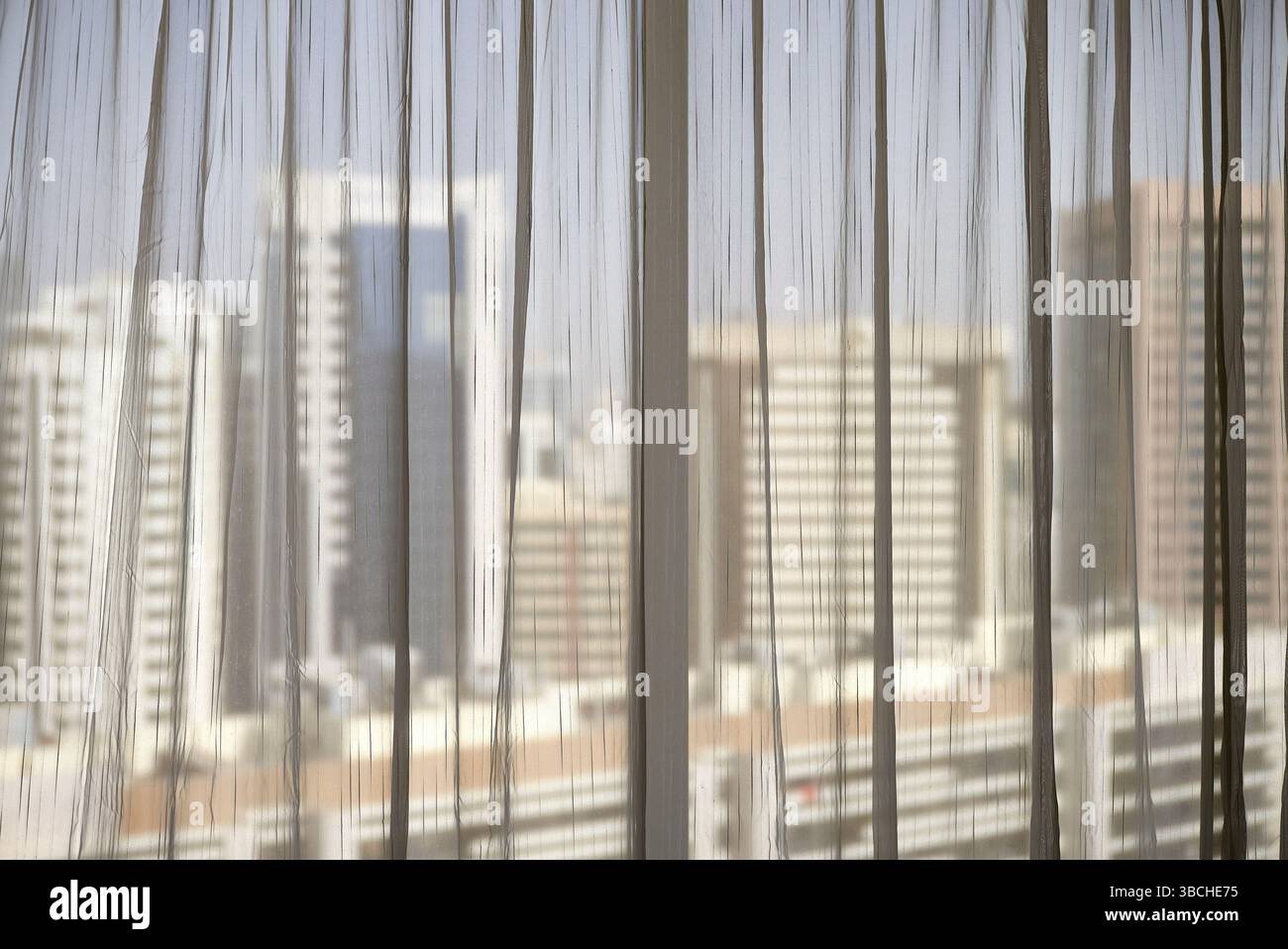 Les grands bâtiments de la ville vus à travers des rideaux transparents de l'intérieur. Abu Dhabi, eau Banque D'Images