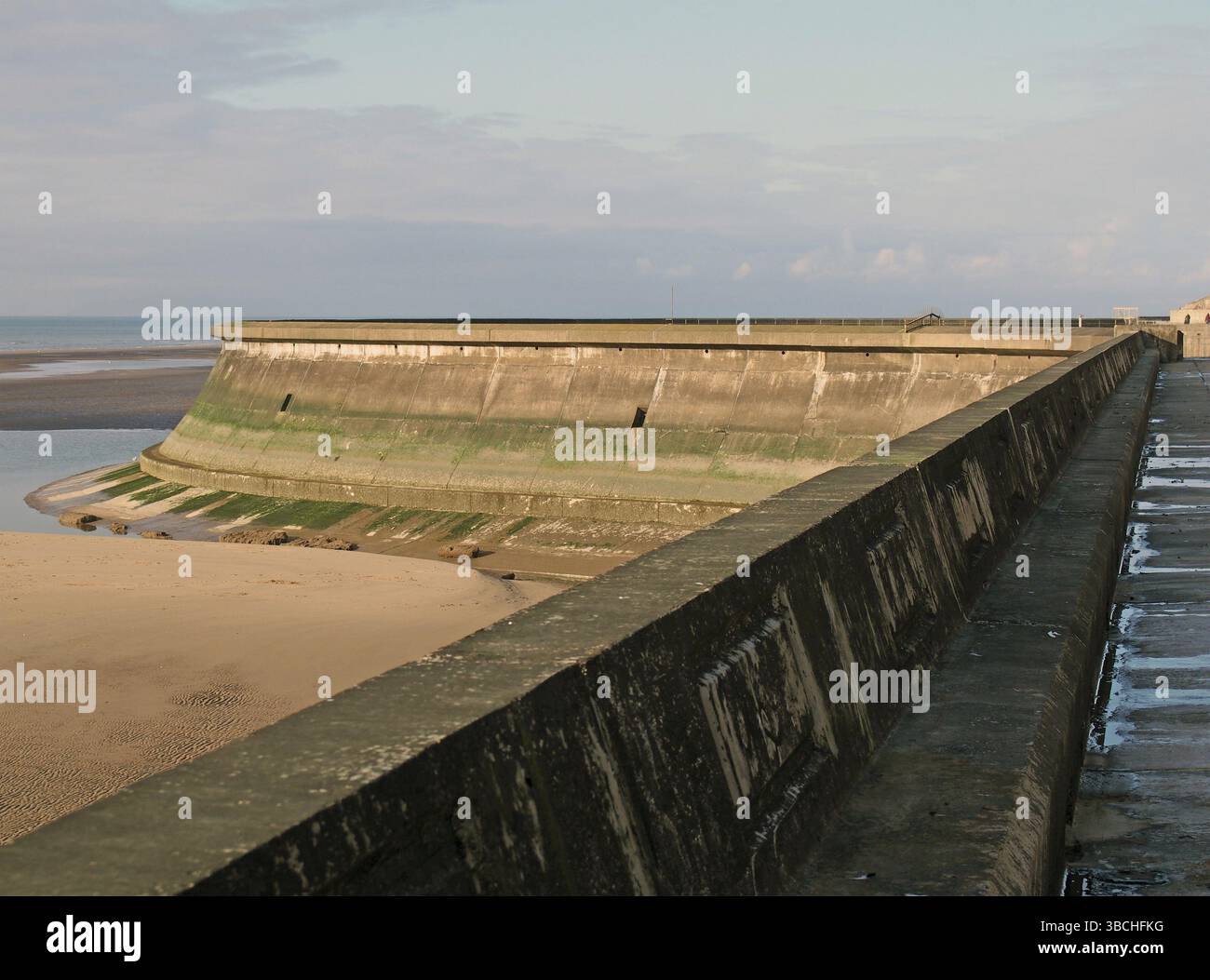 Le sentier côtier de blackpool avec la plage à marée basse en plein soleil avec le mur de la vieille piscine à bateaux Banque D'Images