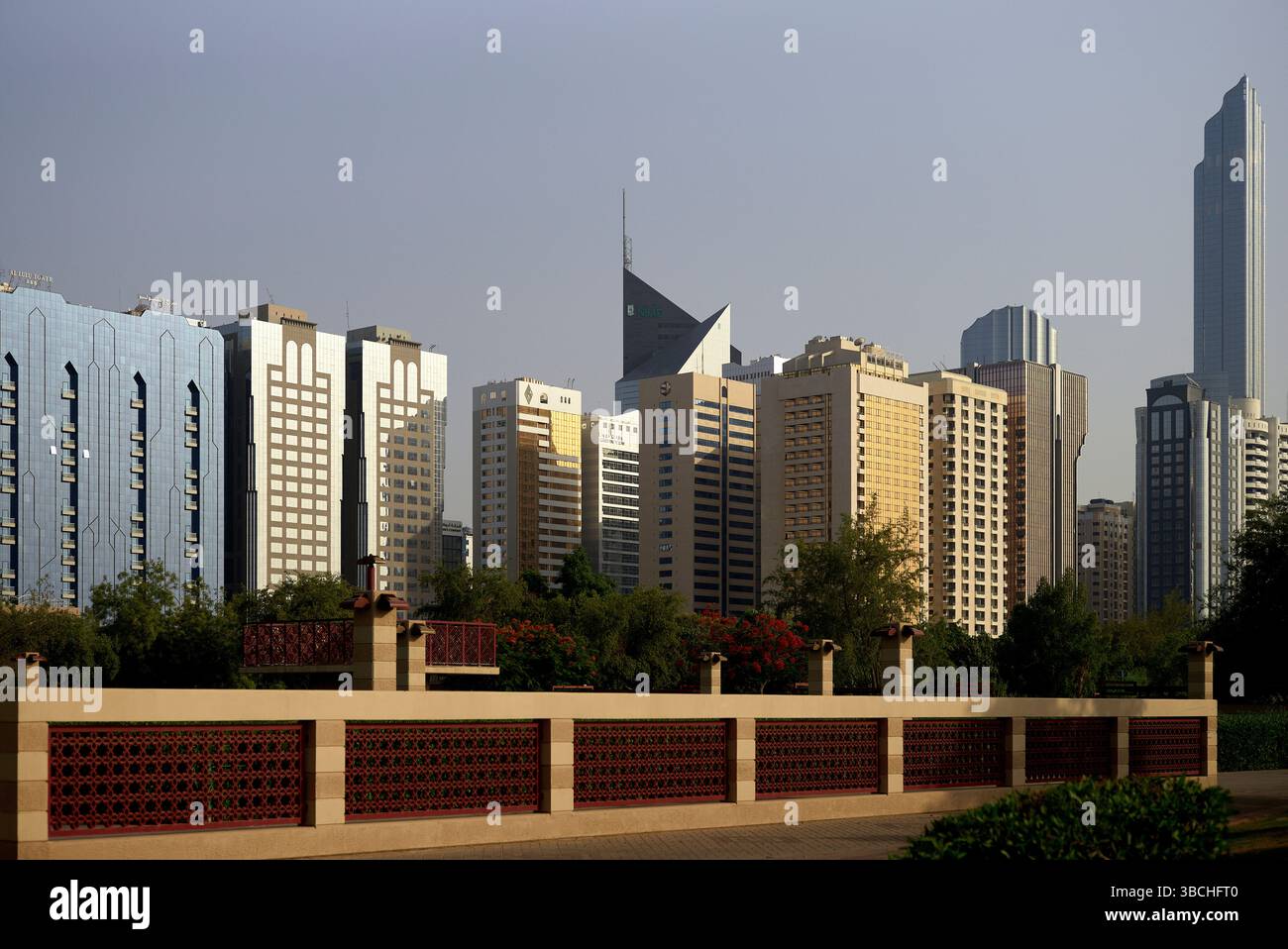 Horizon urbain avec des gratte-ciel modernes et une clôture décorative au premier plan sous ciel clair. Abu Dhabi, eau Banque D'Images