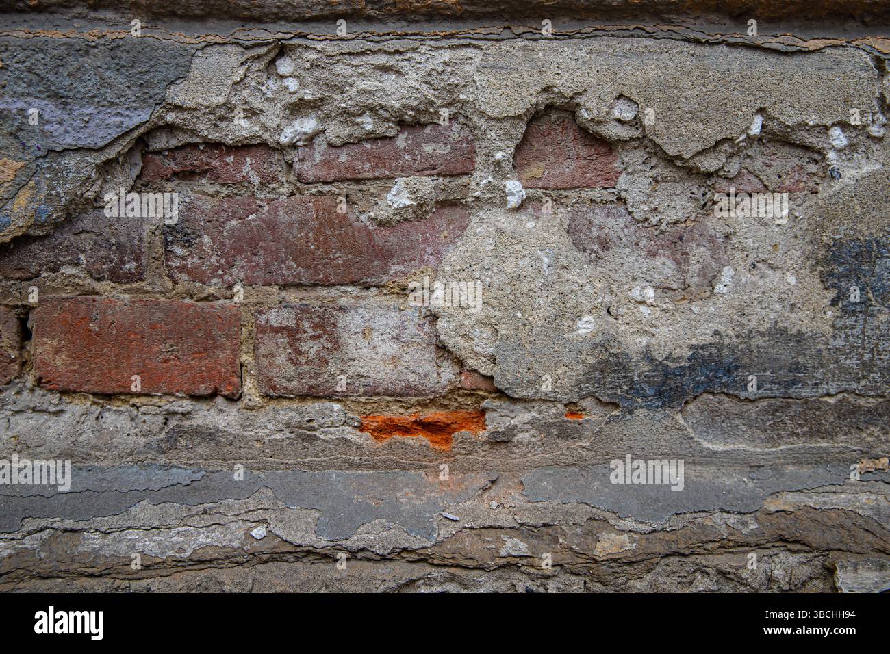 Vieux mur de briques altérées avec plâtre fissuré et surface pelable ancien mur de briques altérées avec plâtre fissuré et surface pelable Banque D'Images