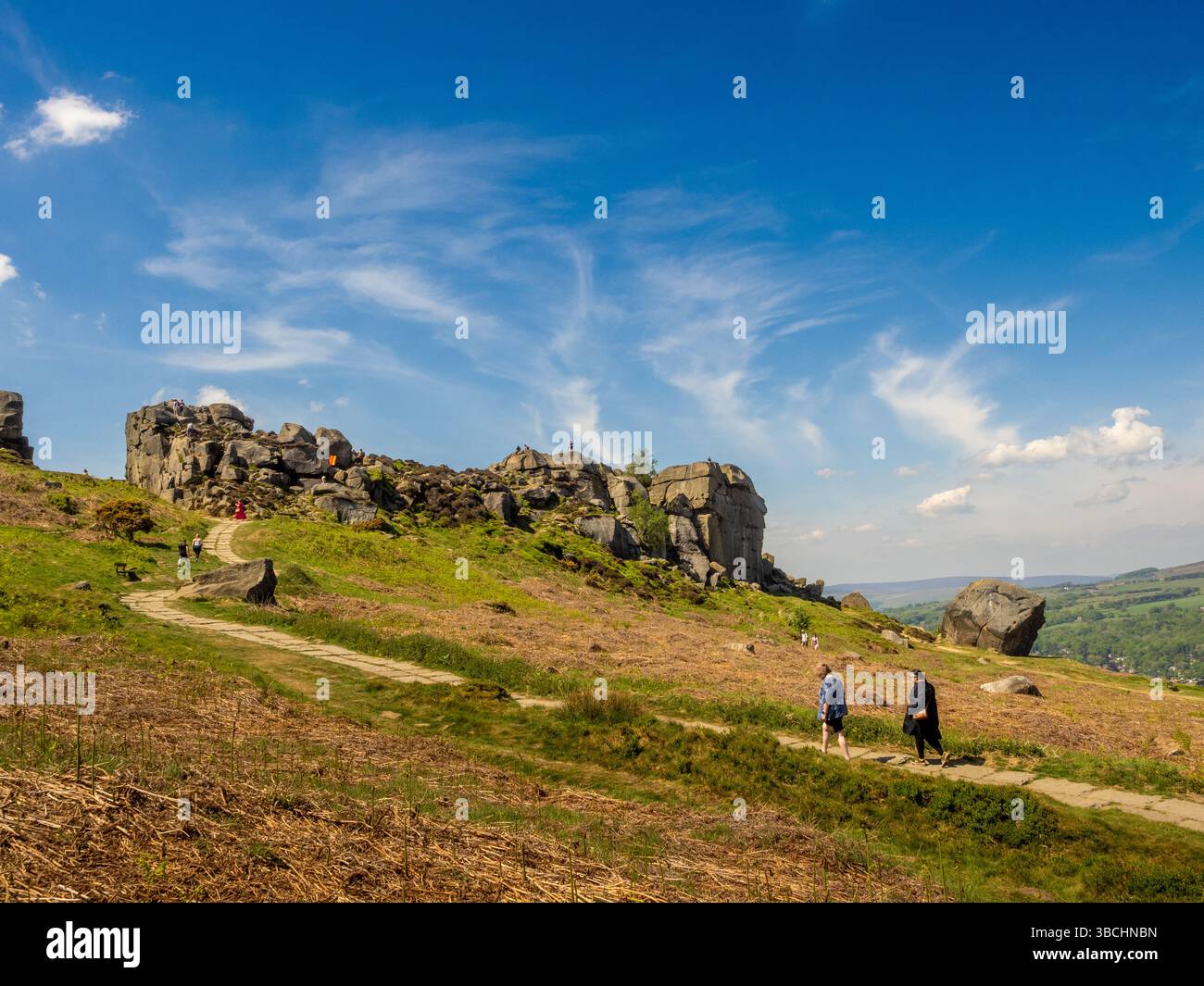 Chemin menant aux rochers de vache et de veau sur Ilkley Moor, avec les gens marchant et profitant de la journée claire et ensoleillée. West Yorkshire. ROYAUME-UNI Banque D'Images