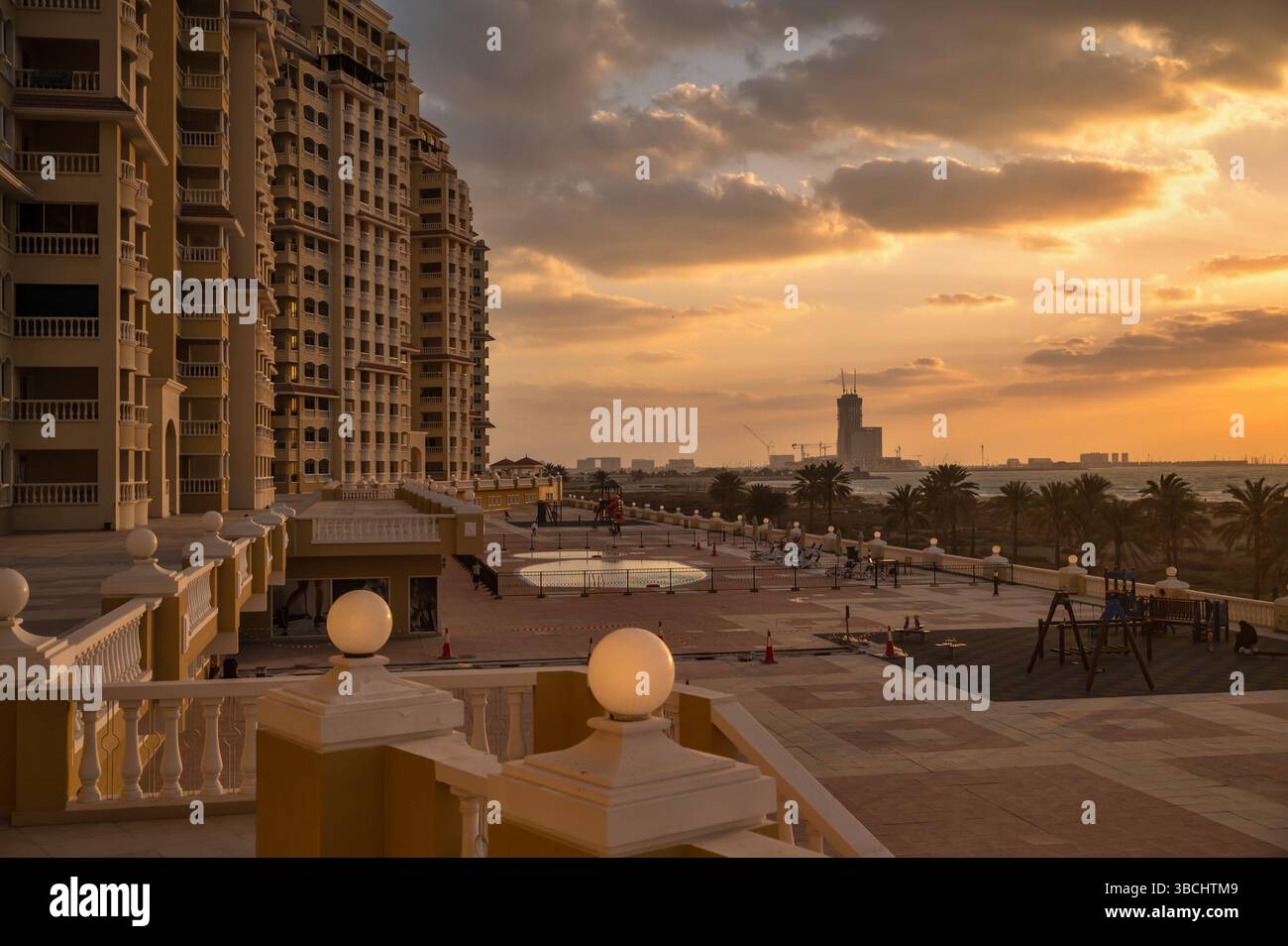 Moody vue sur le coucher du soleil au-dessus de la maison d'appartements à Al Hamra, mer et marine, eau Ras al Khaimah. Banque D'Images