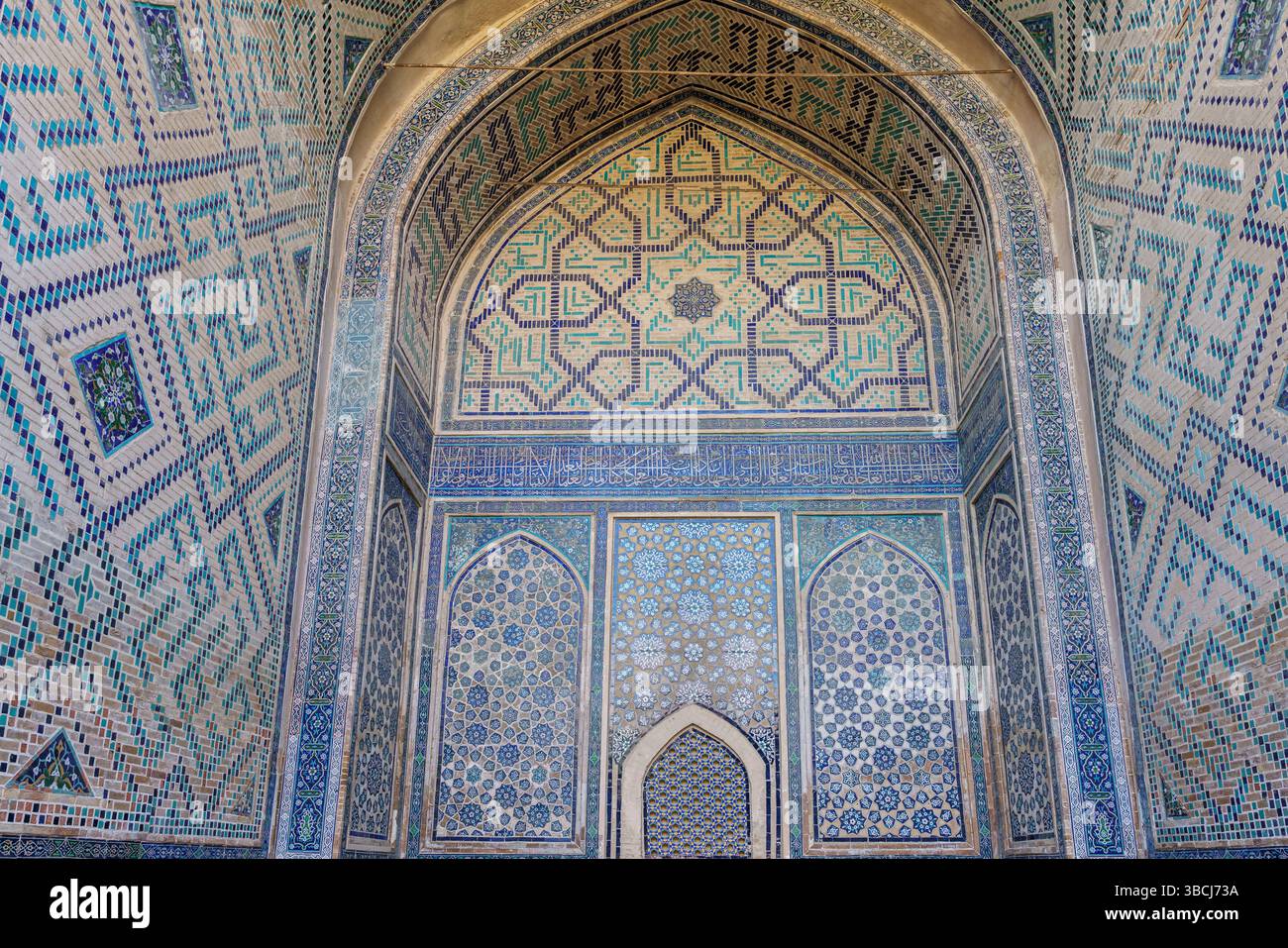 Un panneau complexe de carreaux de mosaïque bleue avec des motifs islamiques géométriques décore le mur intérieur de la Madrasa Ulugh Beg au Registan, Samarcande. Banque D'Images