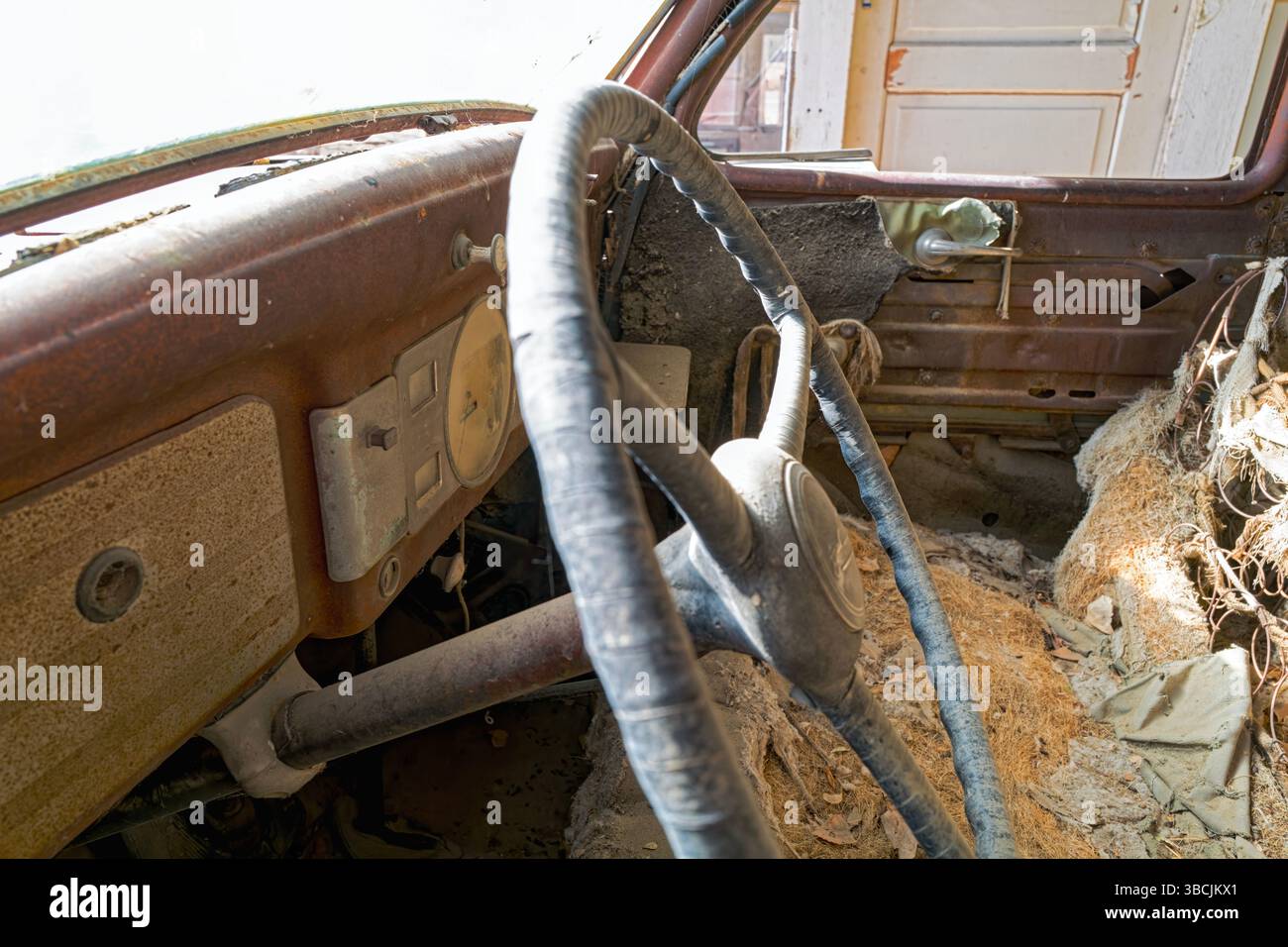 Le tableau de bord et l'intérieur déchiqueté d'une voiture antique qui a été abandonnée dans le désert Banque D'Images