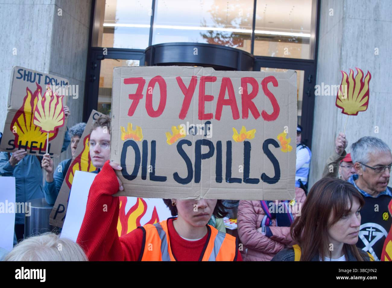Londres, Royaume-Uni. 20 mai 2025. Un manifestant tient une pancarte « 70 ans de déversements d'hydrocarbures » pendant la manifestation. Les militants écologistes se sont rassemblés devant le siège de Shell le jour de l'Assemblée générale annuelle (AGA) du géant des combustibles fossiles, qui s'est tenue à Heathrow où les manifestations sont interdites. Les manifestants exigent que Shell nettoie et verse des indemnités pour ses marées noires dévastatrices dans le delta du Niger au Nigeria. Crédit : SOPA images Limited/Alamy Live News Banque D'Images