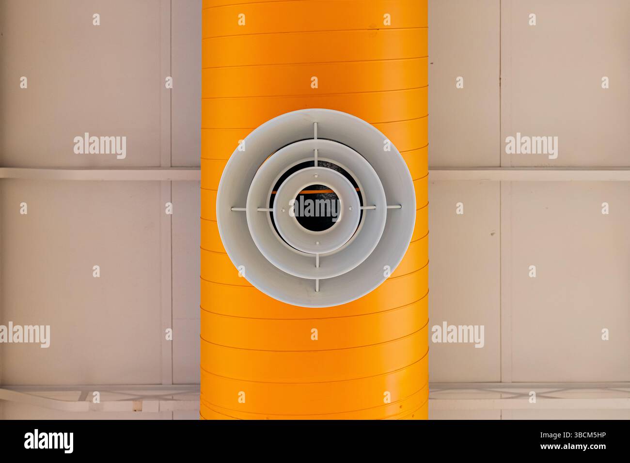 Bâtiment intérieur HVAC, systèmes mécaniques, conduit orange, tuyaux de ventilation, avec diffuseur blanc, suspendu au plafond d'un grand espace ouvert. Banque D'Images
