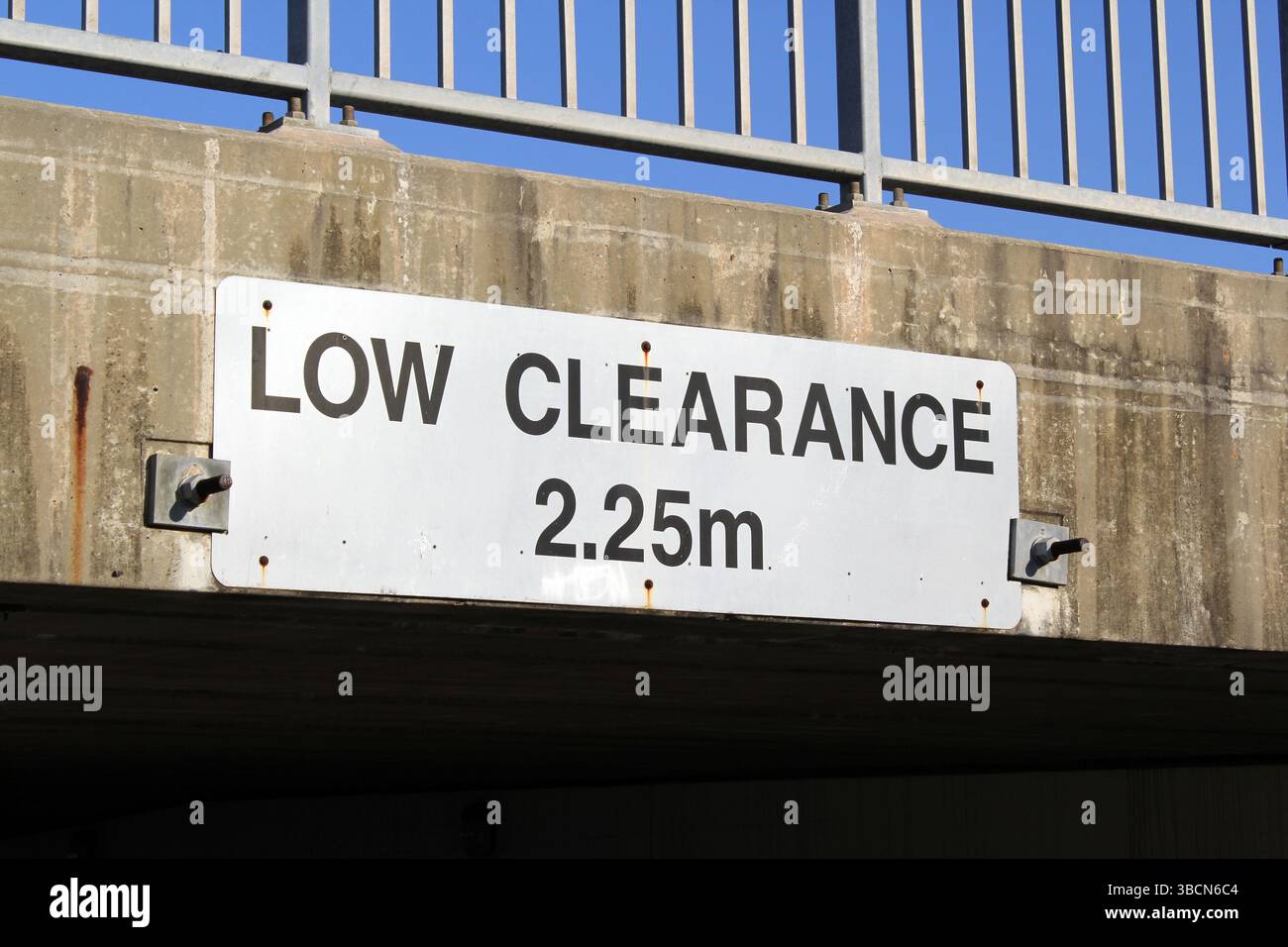 Panneau de limite de hauteur de dégagement faible fixé à un passage inférieur en béton Banque D'Images