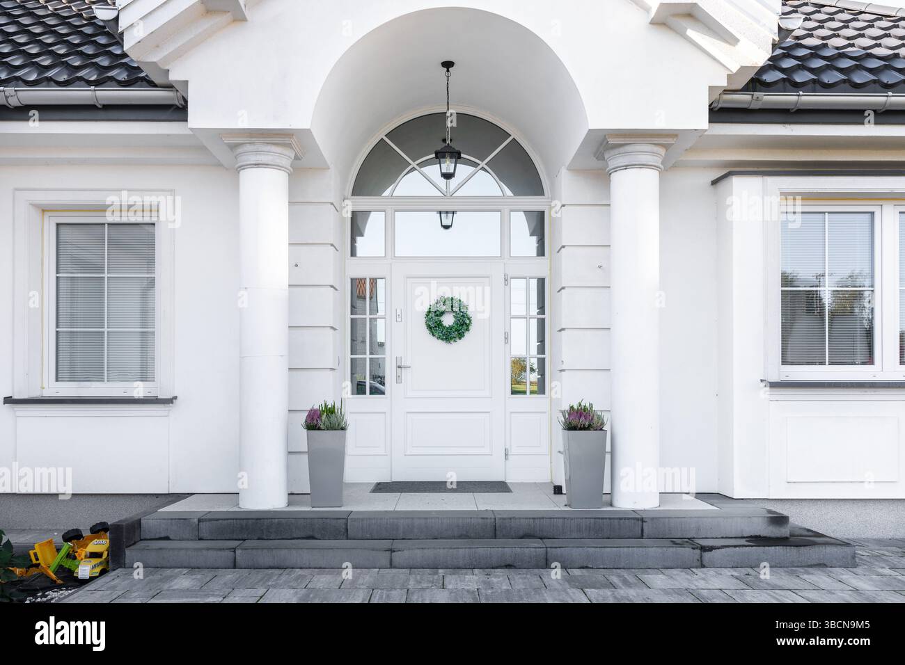 Un détail de porte d'entrée avec un mur d'accent en pierre, porte moderne et luxueuse. Façade extérieure. Portes extérieures. Porte en bois. Banque D'Images
