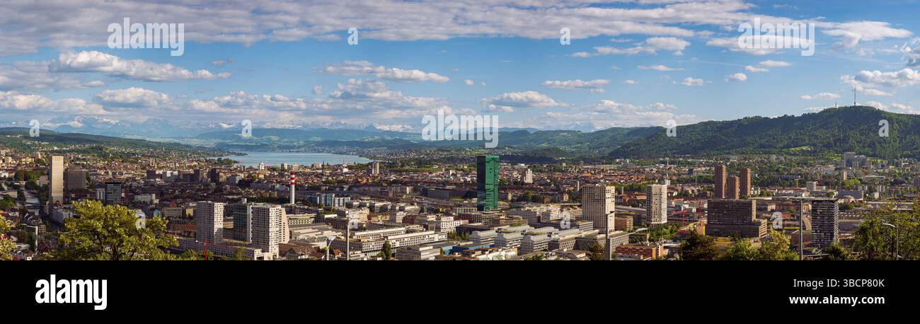 16-05-2025 Zurich, Suisse. Vue panoramique d'en haut comme vu d'un point de vue au sommet d'une colline. Ciel nuageux, Alpes enneigées et lac de Zurich dans le backgrou Banque D'Images