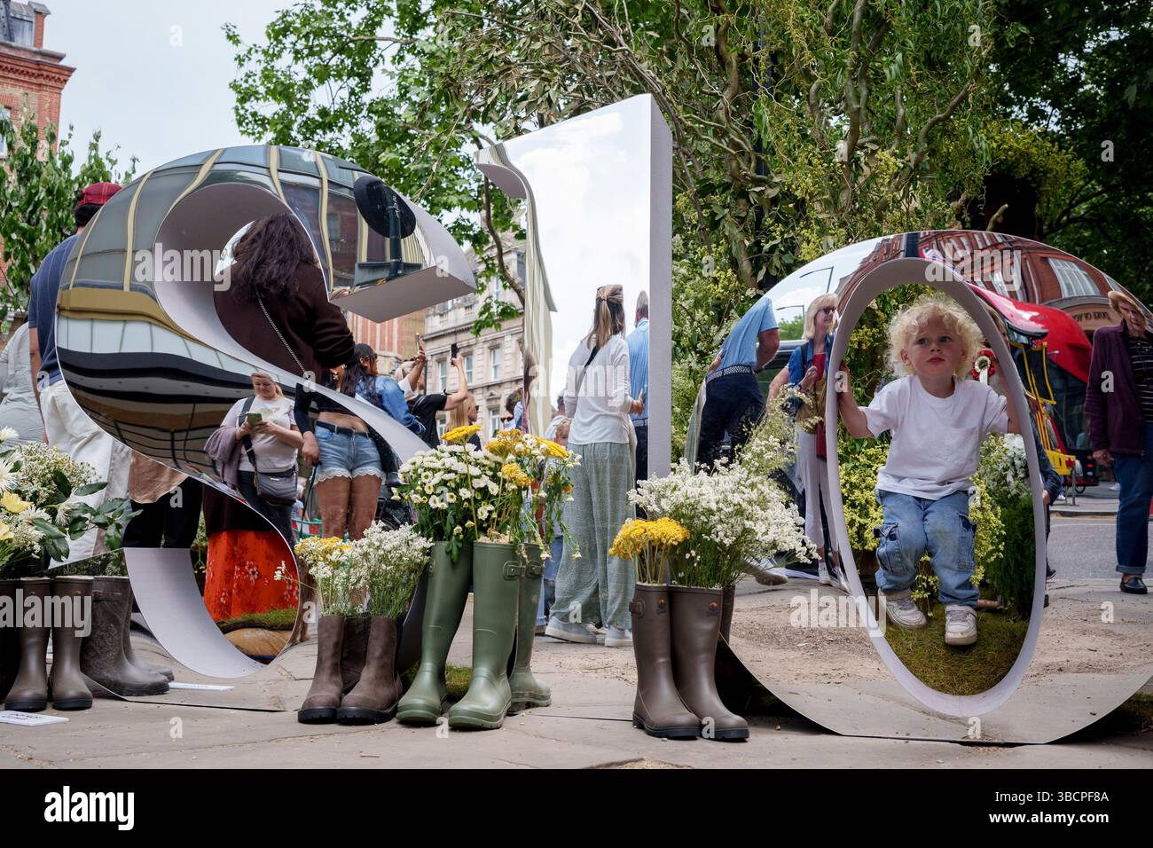 Les enfants jouent entre les miroirs à Sloane Square pendant le Chelsea Flower Show et le festival des fleurs de rue, le 20 mai 2025, à Londres, en Angleterre. Banque D'Images
