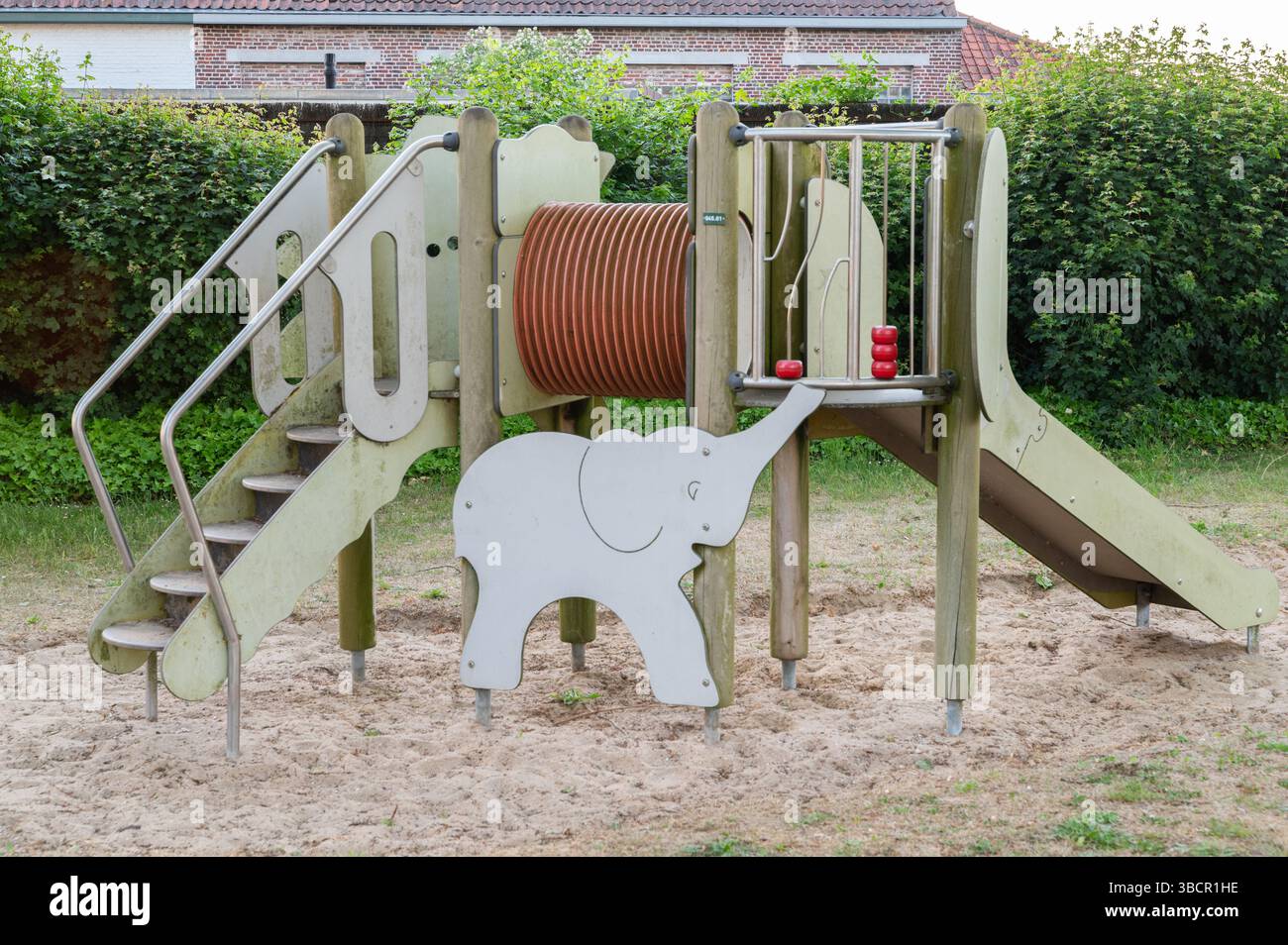 Un terrain de jeu dynamique qui dispose d'un toboggan en forme d'éléphant le long des escaliers, offrant aux enfants un endroit amusant et imaginatif pour jouer à l'extérieur Banque D'Images