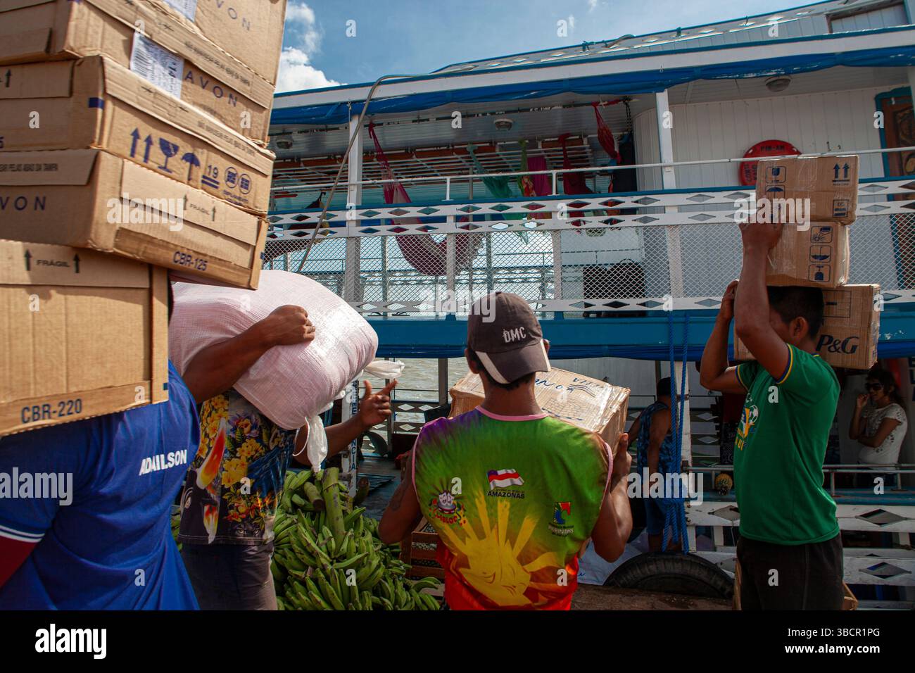 Les dockers chargent diverses marchandises sur les bateaux à aubes traditionnels amazoniens au port de Santarém à Pará, au Brésil. Banque D'Images
