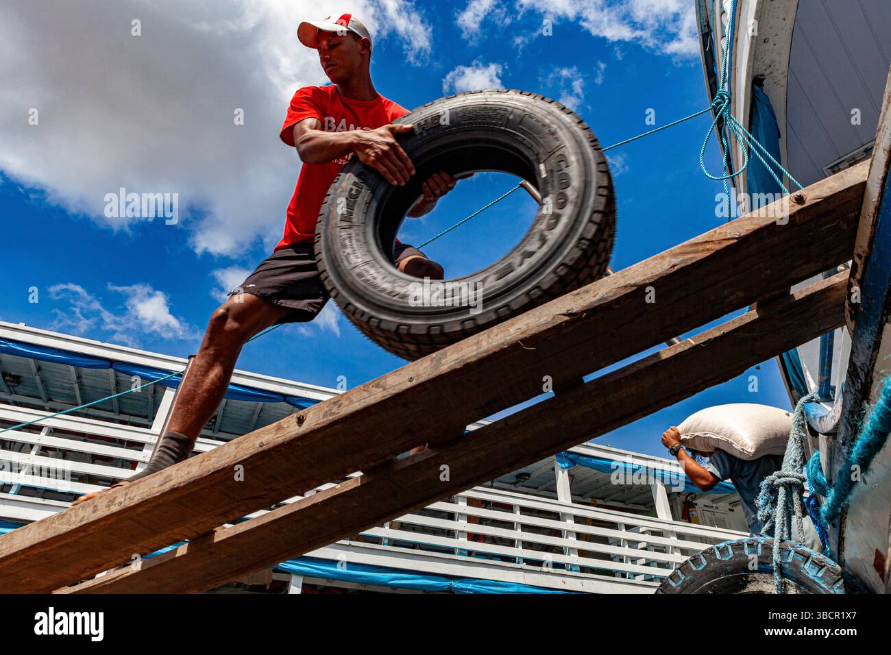 Des ouvriers du port de Santarém à Pará, au Brésil, déchargent des pneus Goodyear d'un bateau fluvial traditionnel d'Amazonie. Banque D'Images