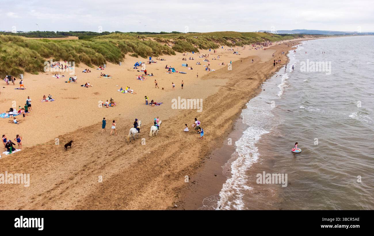Vue aérienne d'Irvine Beach un jour d'été, avec les familles et les visiteurs appréciant la côte sablonneuse de l'Ayrshire dans le sud-ouest de l'Écosse Banque D'Images