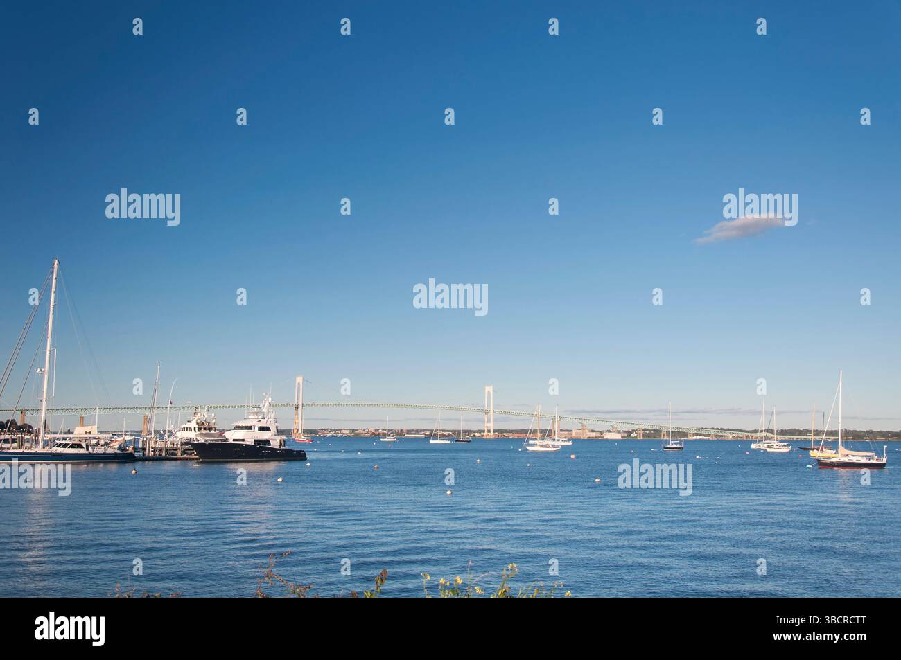Bateaux amarrés dans un port devant le pont Claiborne Pell Newport par une journée ensoleillée. Banque D'Images