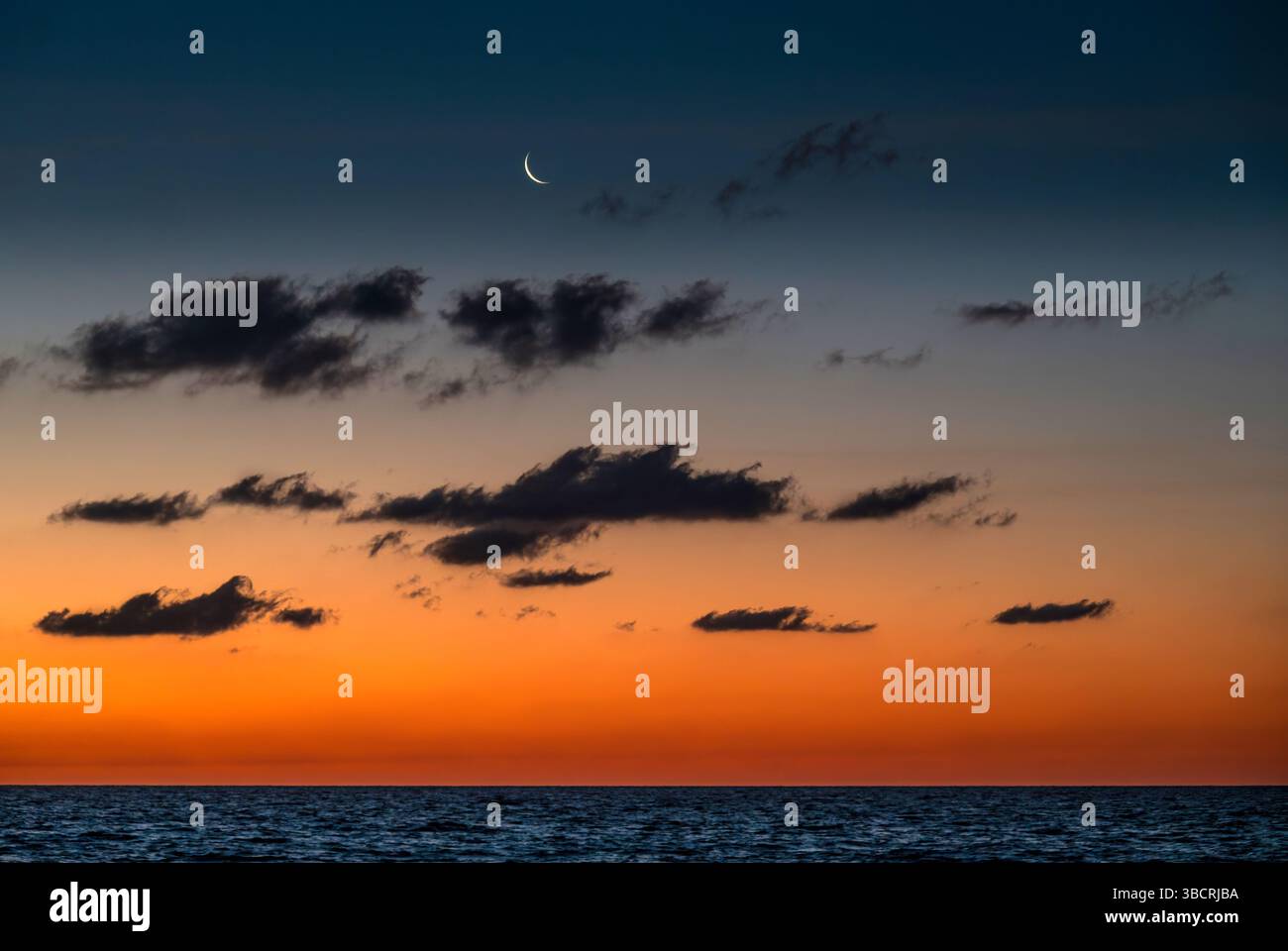 Croissant de lune montant de l'océan Atlantique Banque D'Images