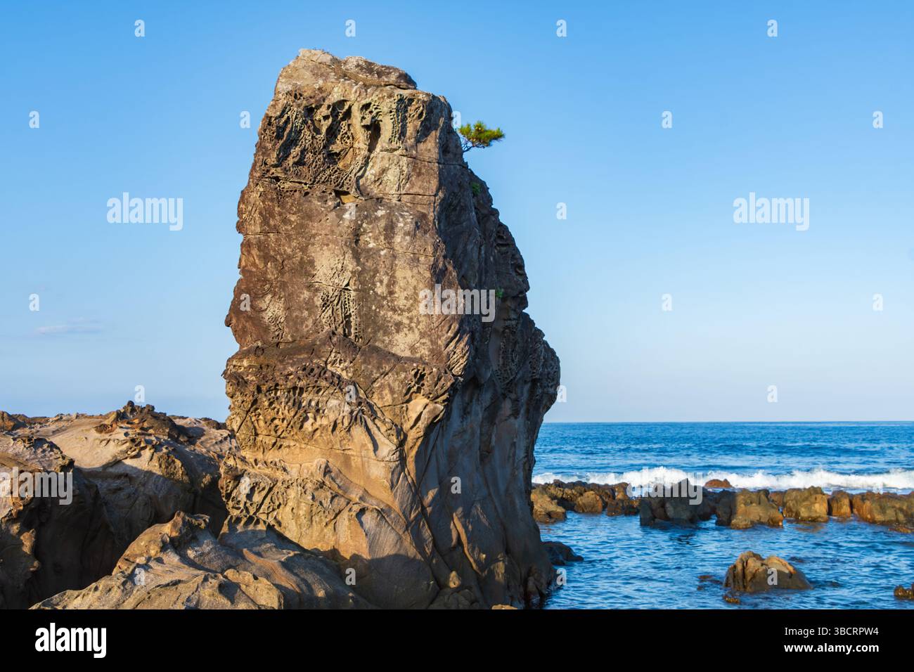Majestueux pilier rocheux côtier s'élevant au-dessus des vagues de l'océan Turquoise Banque D'Images