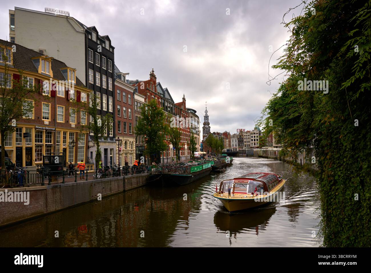 Amsterdam, pays-Bas – 17 septembre 2024 – croisière sur le canal devant le parking à vélos Barge Amsterdam pays-Bas. Une croisière sur le canal passe devant une barge à vélo. Banque D'Images