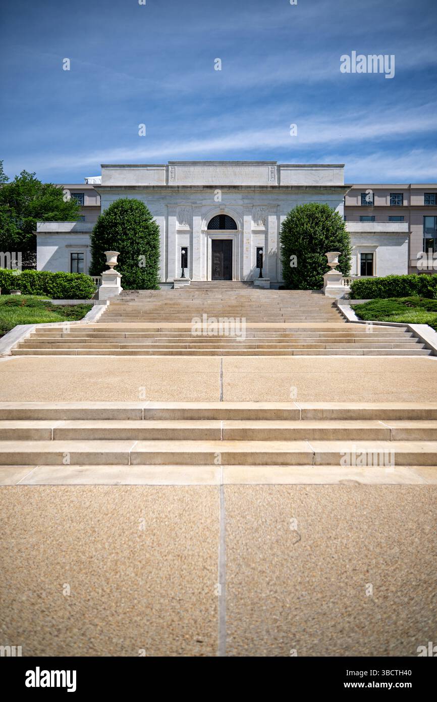 WASHINGTON DC — L'American Pharmacists Association Building se trouve bien en vue sur Constitution Avenue, en face du Lincoln Memorial. Conçue par l'architecte John Russell Pope et achevée en 1934, cette structure néoclassique présente une façade monumentale de temple avec six colonnes doriques soutenant un fronton orné de reliefs sculpturaux représentant l'histoire de la pharmacie. Le siège social en marbre blanc et en calcaire sert à la fois d'espace de bureau pour la première société professionnelle de pharmaciens du pays et de point de repère architectural le long de la bordure nord-ouest du National Mall. Banque D'Images